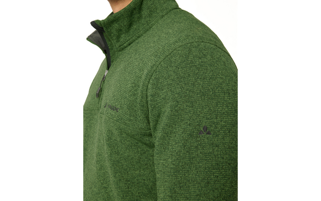 Oberkörper einer Person in grüner Strickfleece-Jacke mit kurzem Reißverschluss, sichtbare Schulter und oberer Arm, kleines dunkles Logo auf der Ärmelaußenseite