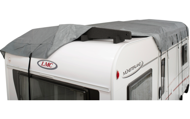Weiße Wohnwagen-Front mit grauer Abdeckplane, schwarzem Schaumstoffstück auf dem Dach und LMC-Logo