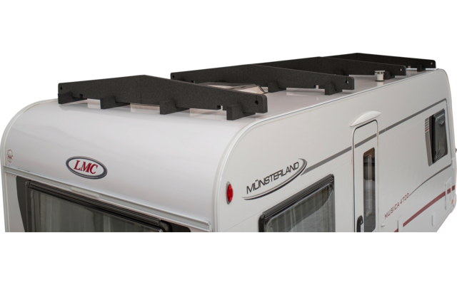 Weiße Vorderansicht eines Wohnwagens mit Dachreling, seitlichen Fenstern und den Logos 'LMC' und 'MÜNSTERLAND'