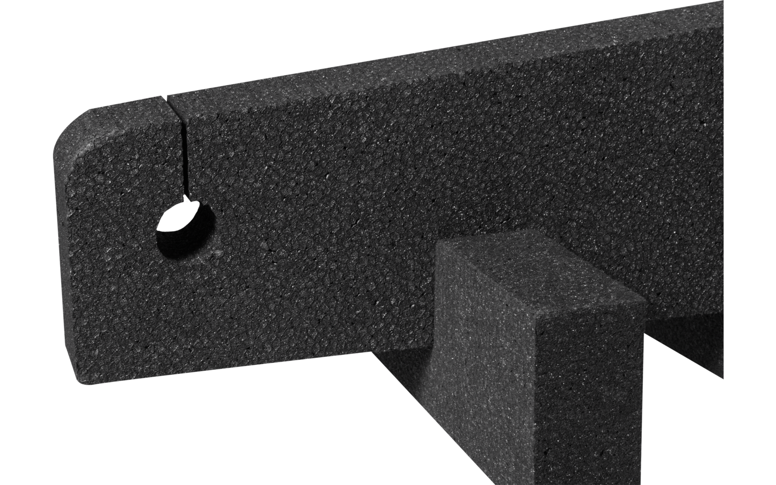 Schwarzes Schaumstoffteil mit abgerundeter Oberkante, rundem Loch links und rechteckiger Stütze darunter