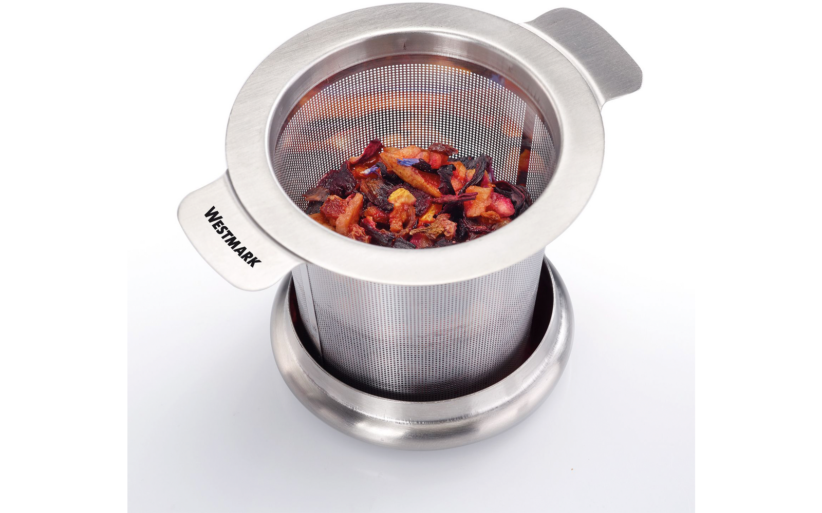 Infuseur à thé en acier inoxydable avec maille fine contenant morceaux de fruits séchés sur une petite soucoupe ; marquage "WESTMARK" sur la poignée