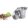 Infuseur à thé en acier inoxydable avec couvercle à côté de feuilles de thé en vrac et d'une feuille de menthe sur fond blanc