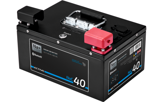 Schwarzes rechteckiges Gehäuse mit Metallgriff oben, einem roten und einem schwarzen Anschlusspol und Aufklebern mit Texten und Zahlen