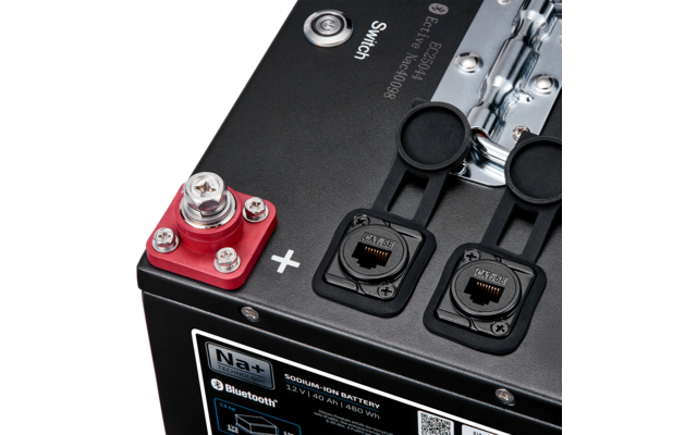 Schwarzes Batteriegehäuse mit roter Plus-Klemme, zwei RJ45-Buchsen mit Gummiklappen und Etikett