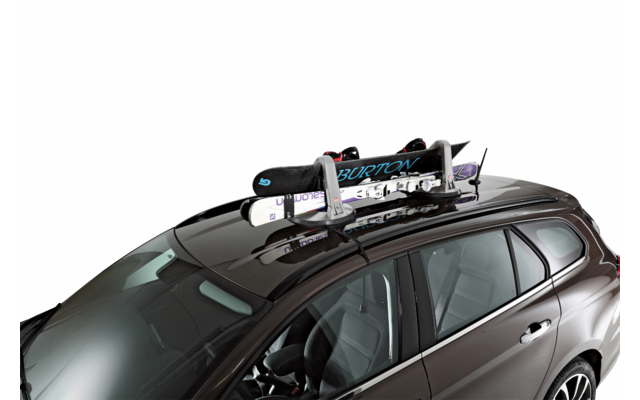 Auto scura con portapacchi sul tetto che sostiene due snowboard con attacchi, uno con la scritta 'BURTON'