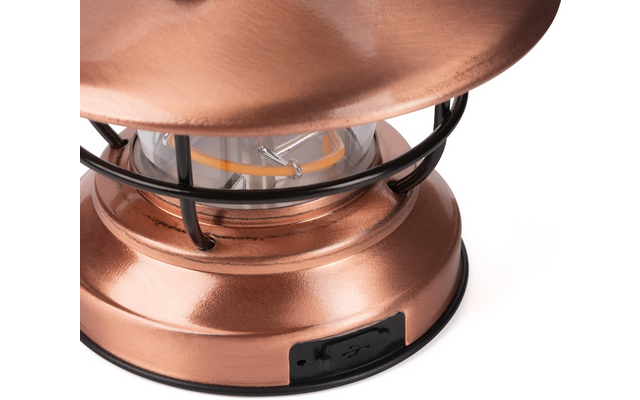 Close-up van een koperen lantaarn met een glazen lamp, zwart metalen rooster en zichtbare USB-poort