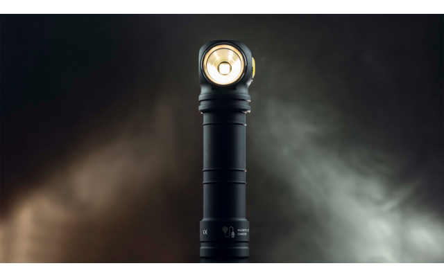 Taschenlampe mit eingeschaltetem Licht auf dunklem Hintergrund