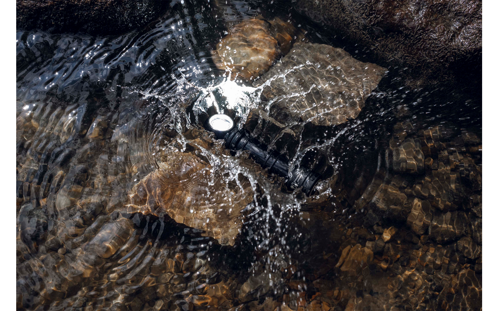 Wasser fließt über Steine und bildet Blasen