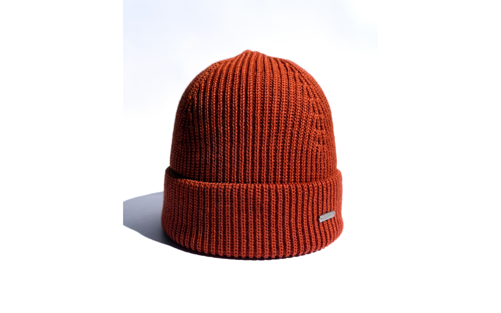 Rostrote gestrickte Mütze auf weißem Hintergrund