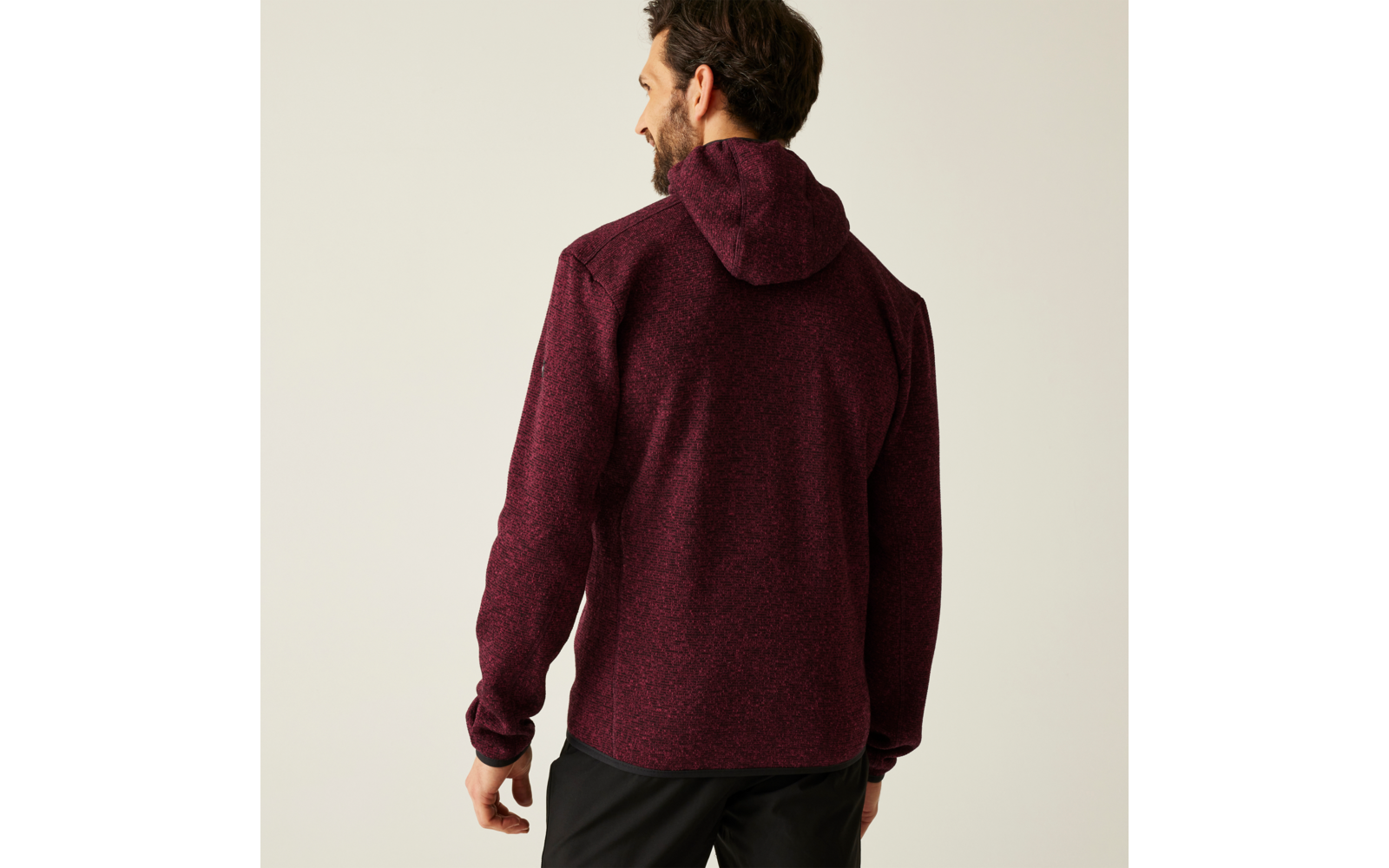 Mann von hinten mit dunkelrotem Kapuzenpullover vor hellem Hintergrund