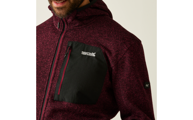 Oberkörper einer Person, die einen rot melierten Pullover mit schwarzer Brusttasche trägt