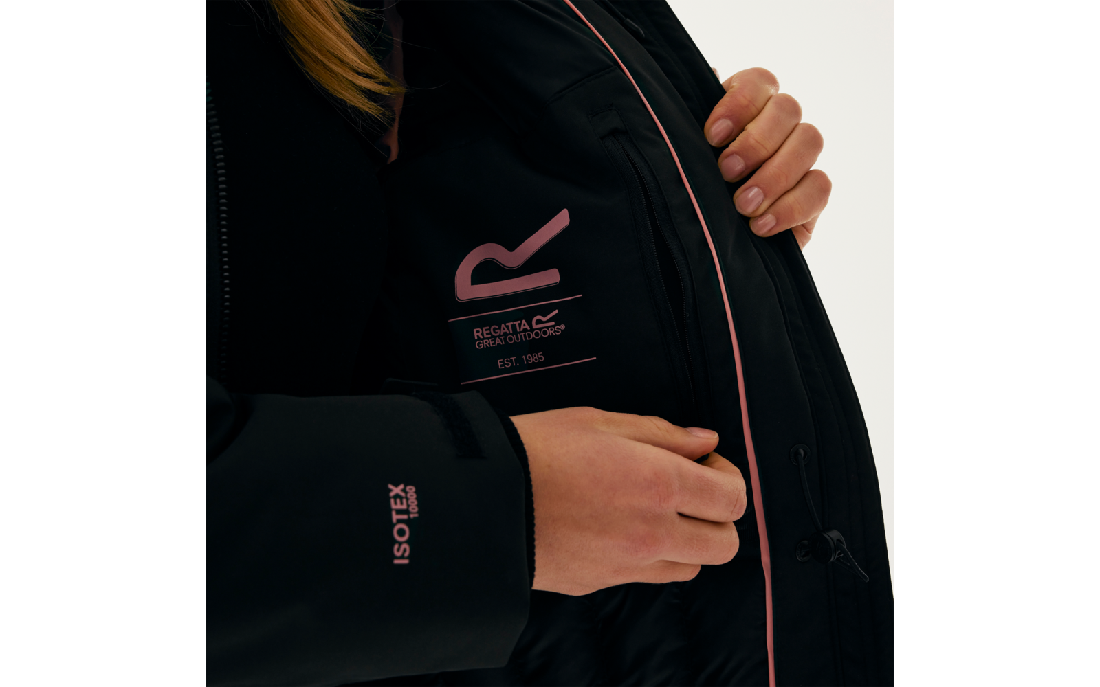 Person öffnet die Innenseite einer schwarzen Jacke, auf der ein Logo und Text sichtbar sind