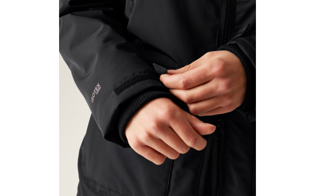 Hände, die den Ärmel einer schwarzen Jacke schließen