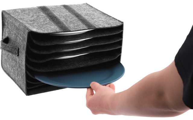 Grijs vilten bakje met meerdere horizontale vakken, een blauw rond bord wordt eruit getrokken door een hand; onderarm en zijkant van de romp zichtbaar