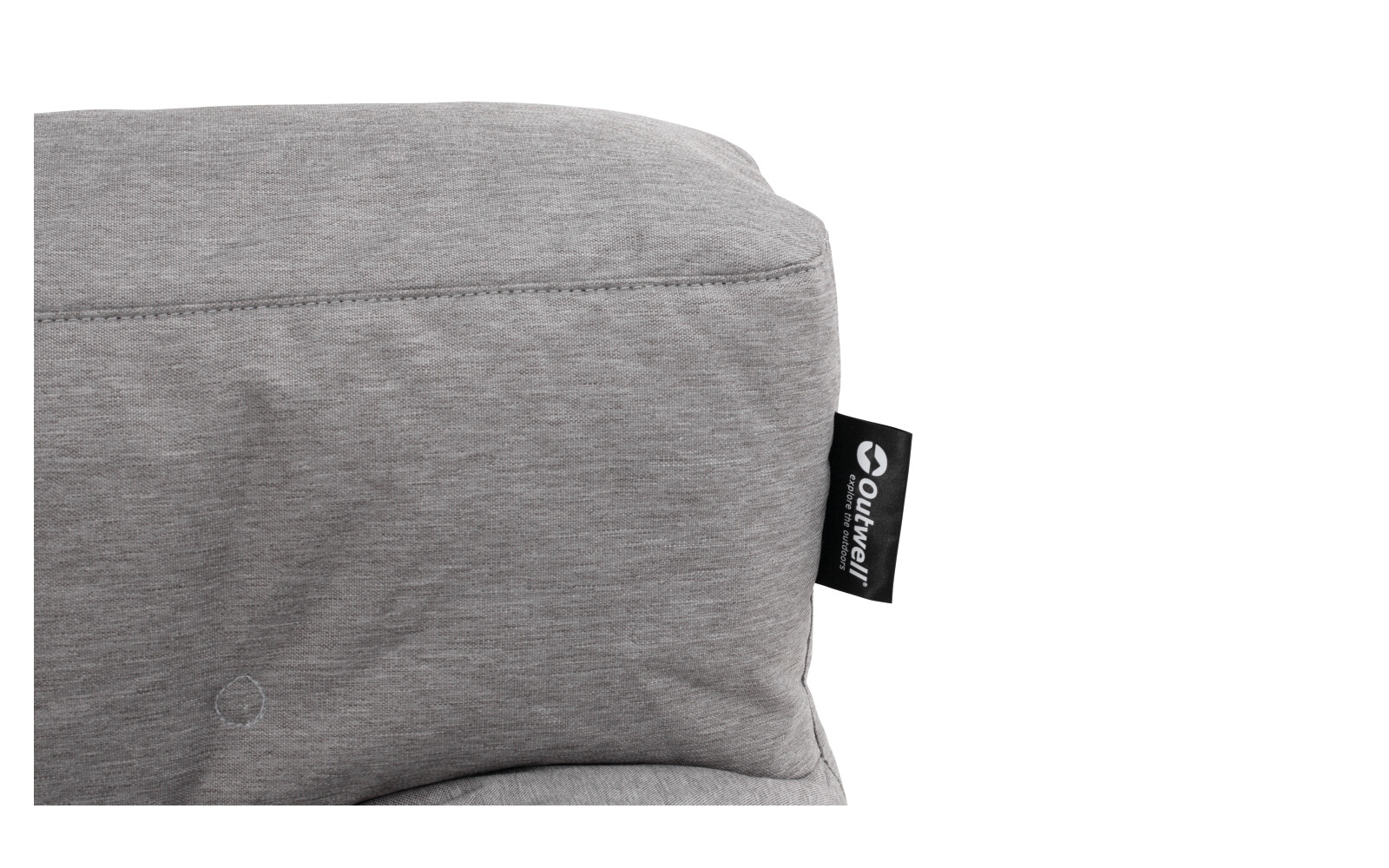 Coussin matelassé gris clair avec couture visible et étiquette noire à texte blanc