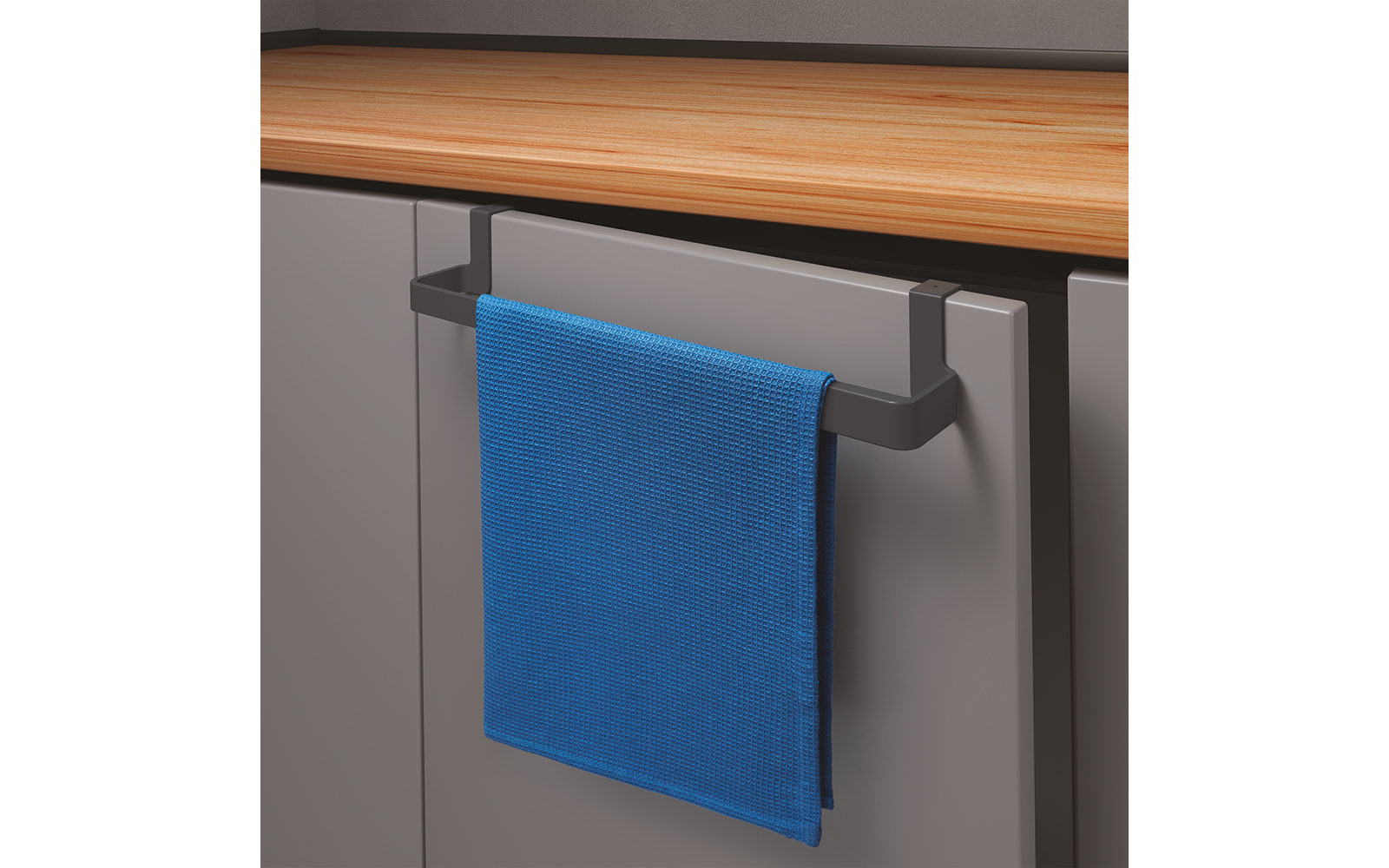 Blauwe handdoek hangt aan een greepstang aan een grijze keukenkast onder een houten aanrechtblad