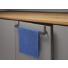 Blauw handdoek hangt aan een handvat van een grijze kast onder een houten tafel