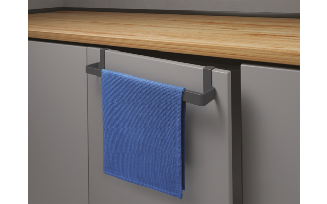 Blauw handdoek hangt aan een handvat van een grijze kast onder een houten tafel