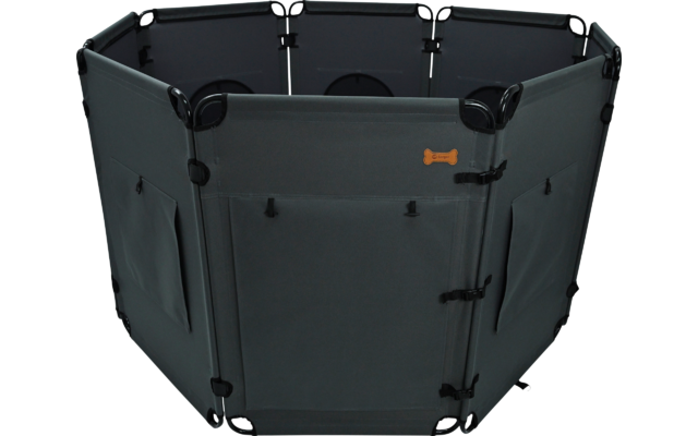 Hexagonal dark gray fabric structure with six connected panels; front panel with a door and buckles; side panels with pockets; small orange bone-shaped patch on the front