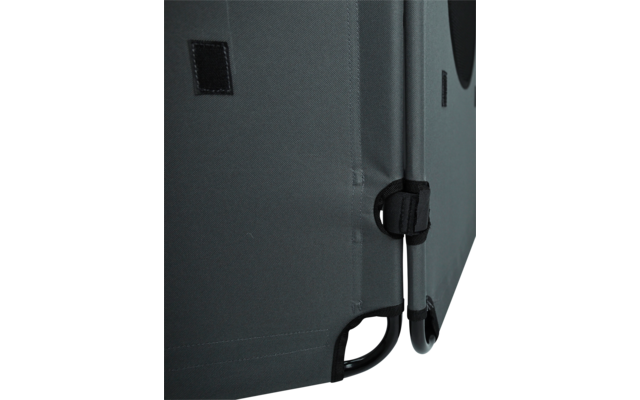 Close-up of gray fabric covering with seam, small Velcro patch, black strap with buckle, and black metal frame at the bottom