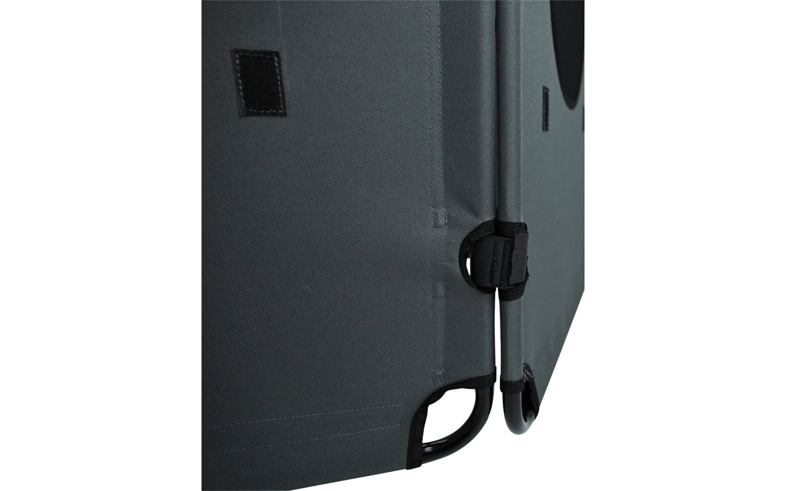 Close-up of gray fabric covering with seam, small Velcro patch, black strap with buckle, and black metal frame at the bottom