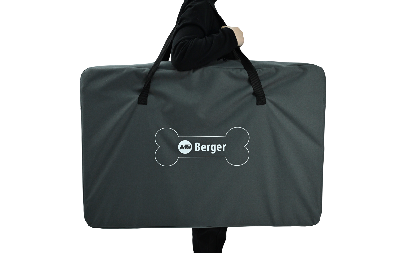 Large dark gray rectangular carrying bag with two black handles and a white Berger logo inside a bone-shaped outline; person partially visible (torso and arm in black clothing); white background