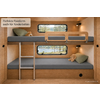 Houten stapelbed met metalen ladder, grijze matrassen, bovenste veiligheidsleuning, twee rechthoekige ramen met uitzicht op meer en bomen, knuffels en groene kussens op de bedden, wandlampen, ronde zwarte opening; linksboven sticker ‘Perfekte Passform auch für Kinderbetten’, rechtsonder tekst ‘KI-generiertes Bild’
