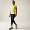 Personne debout en T‑shirt jaune, legging noir et baskets beiges sur fond clair
