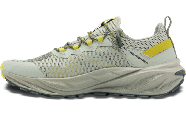 Sneaker in heller Farbe mit gelben Details von der Seite