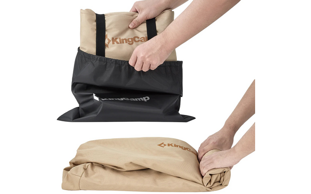 Hände falten eine beige Tragetasche in eine schwarze Hülle mit Reißverschluss