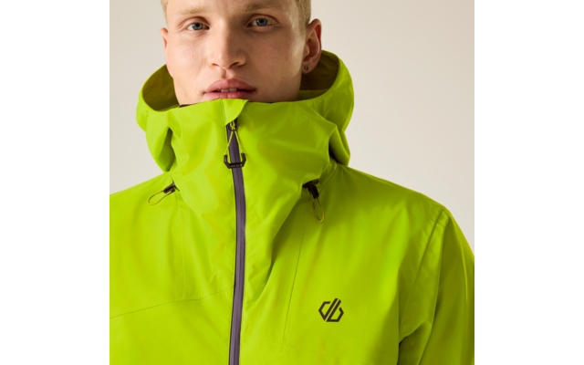 Nahaufnahme einer Person mit kurzem blondem Haar, die eine hellgrüne Kapuzenjacke bis zum Kinn geschlossen trägt; kleines Logo auf der Brust; Ohrpiercing sichtbar