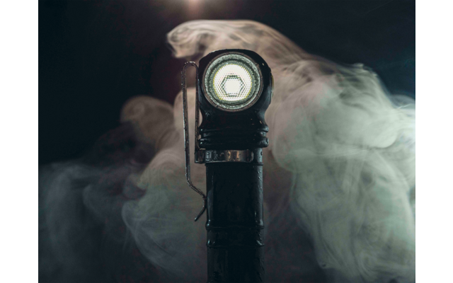 Nahaufnahme einer leuchtenden Taschenlampe mit Nebel im Hintergrund