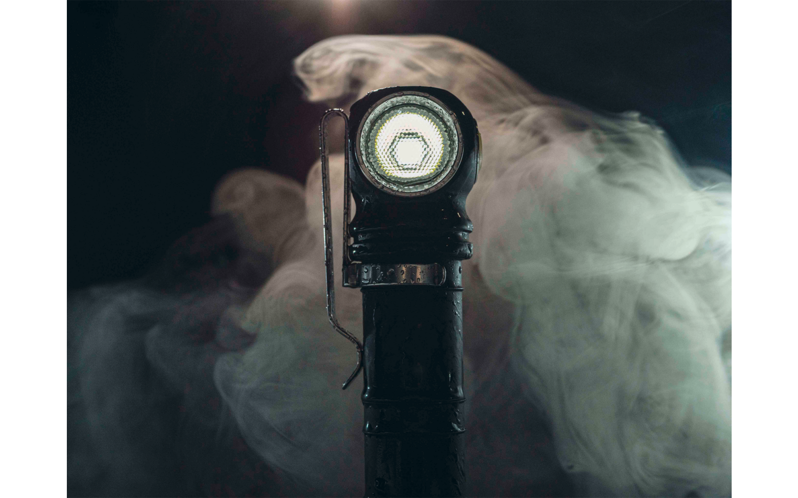 Nahaufnahme einer leuchtenden Taschenlampe mit Nebel im Hintergrund