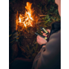 Eine Person macht ein Lagerfeuer im Wald, das Feuer brennt hell