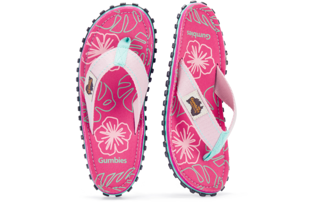 Zwei pinke Zehensandalen mit weißen Riemen und türkisfarbenem Einsatz, floral gemusterte Fußbetten mit Aufdruck 'Gumbies', schwarze profilierte Sohlen mit Noppen