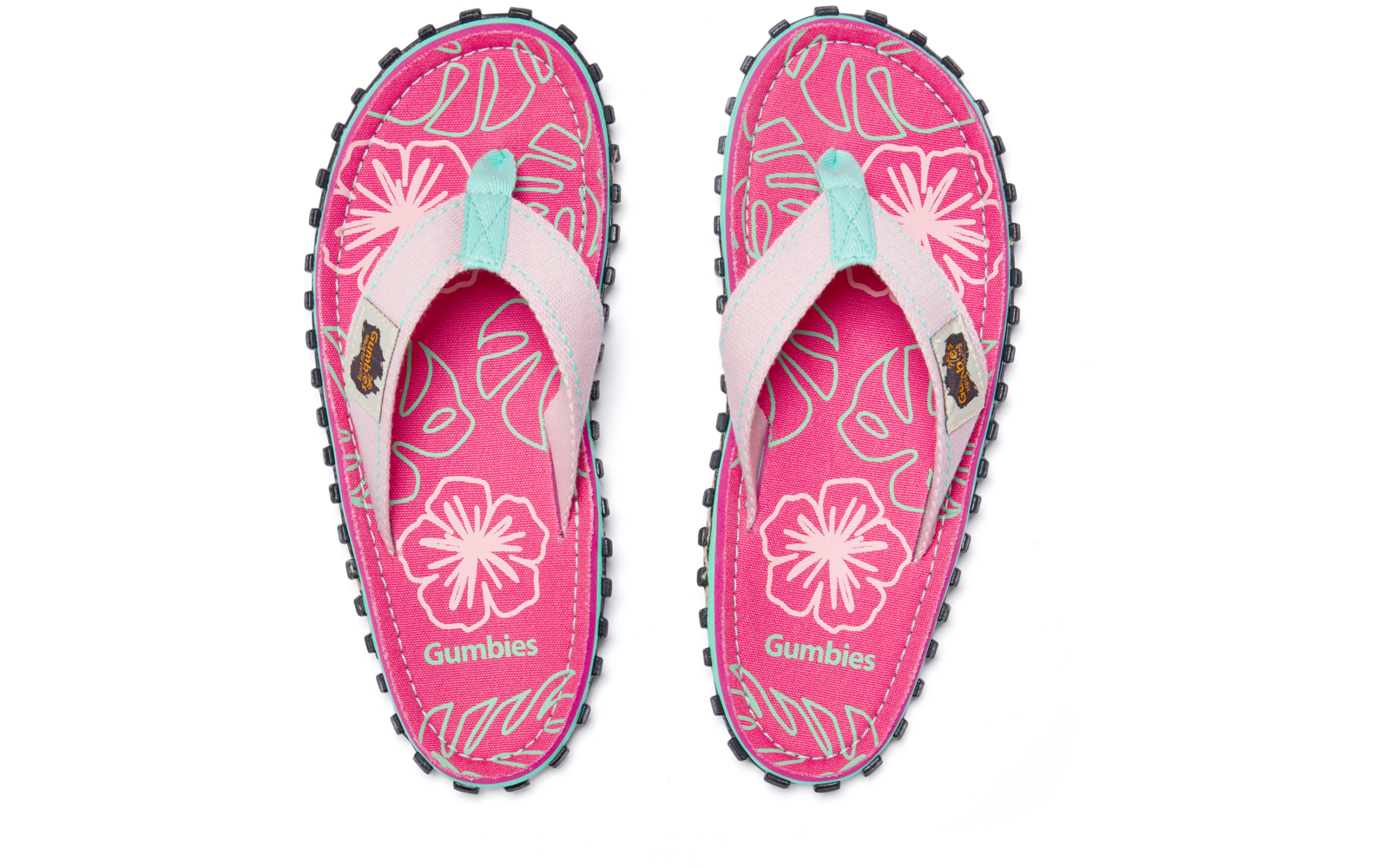 Zwei pinke Zehentrenner von oben, weißes Blumenmuster, hellblaue Riemenakzente, schwarze profilierte Sohlen, 'Gumbies'-Logo auf den Innensohlen