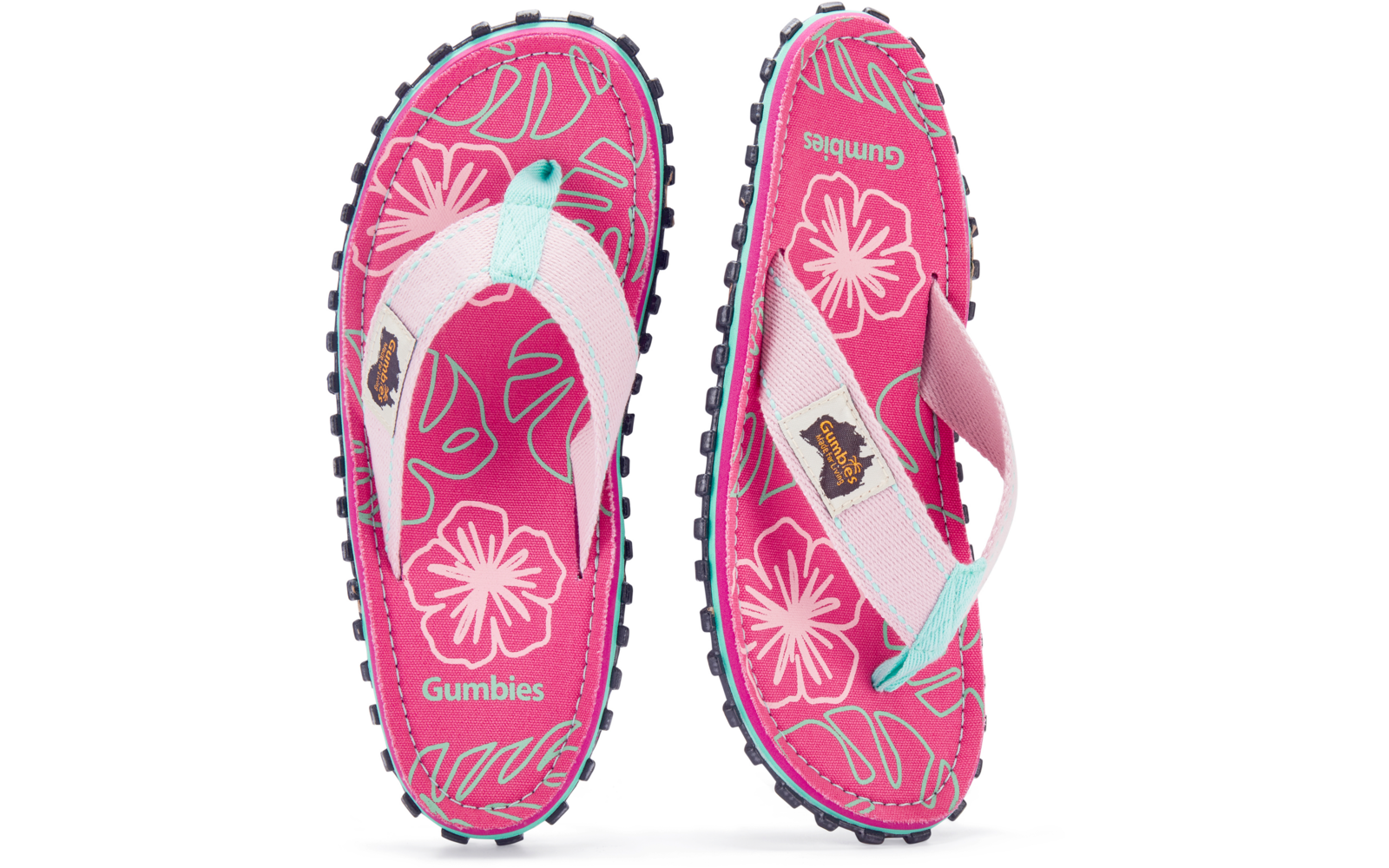 Zwei pinke Zehensandalen mit weißen Riemen und türkisfarbenem Einsatz, floral gemusterte Fußbetten mit Aufdruck 'Gumbies', schwarze profilierte Sohlen mit Noppen
