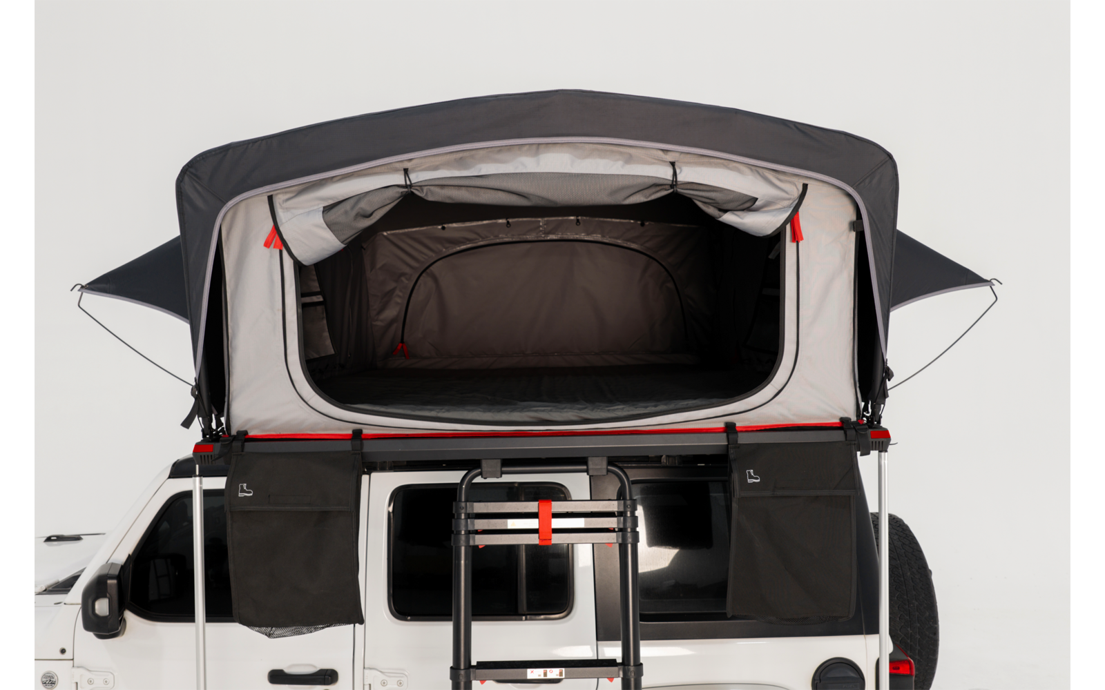 Offenes Dachzelt auf weißem Campingbus, Leiter zum Einstieg, dunkler Innenraum