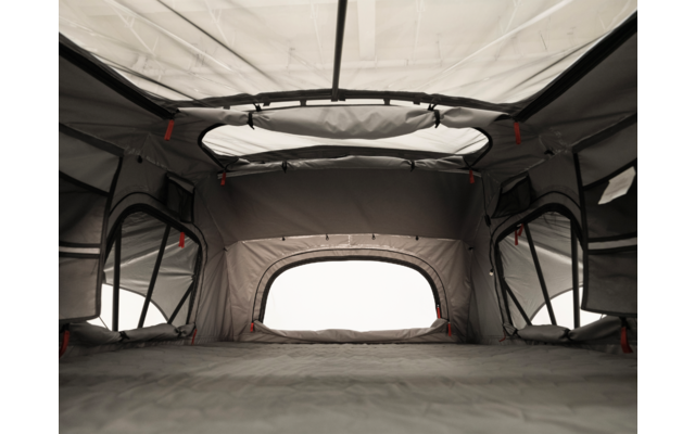 Innenansicht eines grauen Zeltes mit runder Dachöffnung, Stoffwänden, vier Fenstern mit Netz und einer flachen Bodenfläche