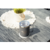 Tasse grise avec couvercle et anse sur une table en bois grise ; à côté, un pot de plante clair avec une petite plante verte sur un napperon rond blanc en crochet