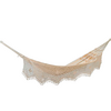 Hamaca beige con flecos en ambos extremos, tensada entre postes de madera