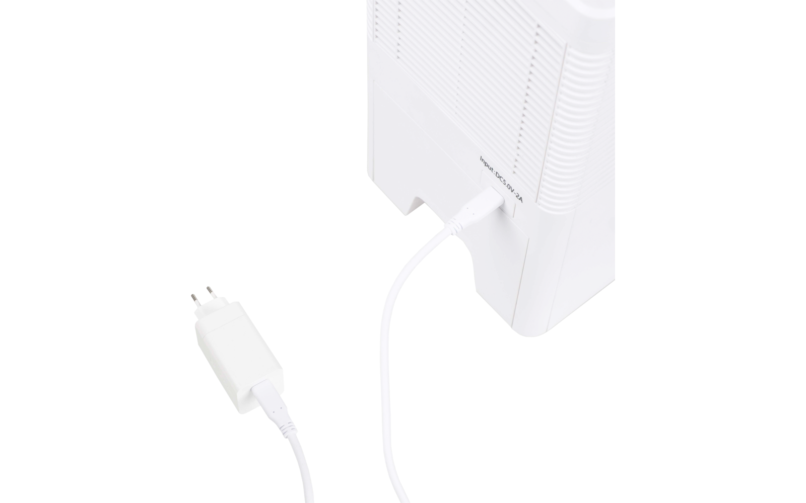 Weißes Gerät mit Lüftungsschlitzen; an der Rückseite steckt ein weißes Kabel, das zu einem weißen Netzstecker mit zwei runden Stiften führt