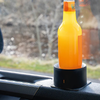 Una botella naranja está colocada en un soporte negro dentro de un coche
