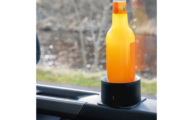 Una botella naranja está colocada en un soporte negro dentro de un coche