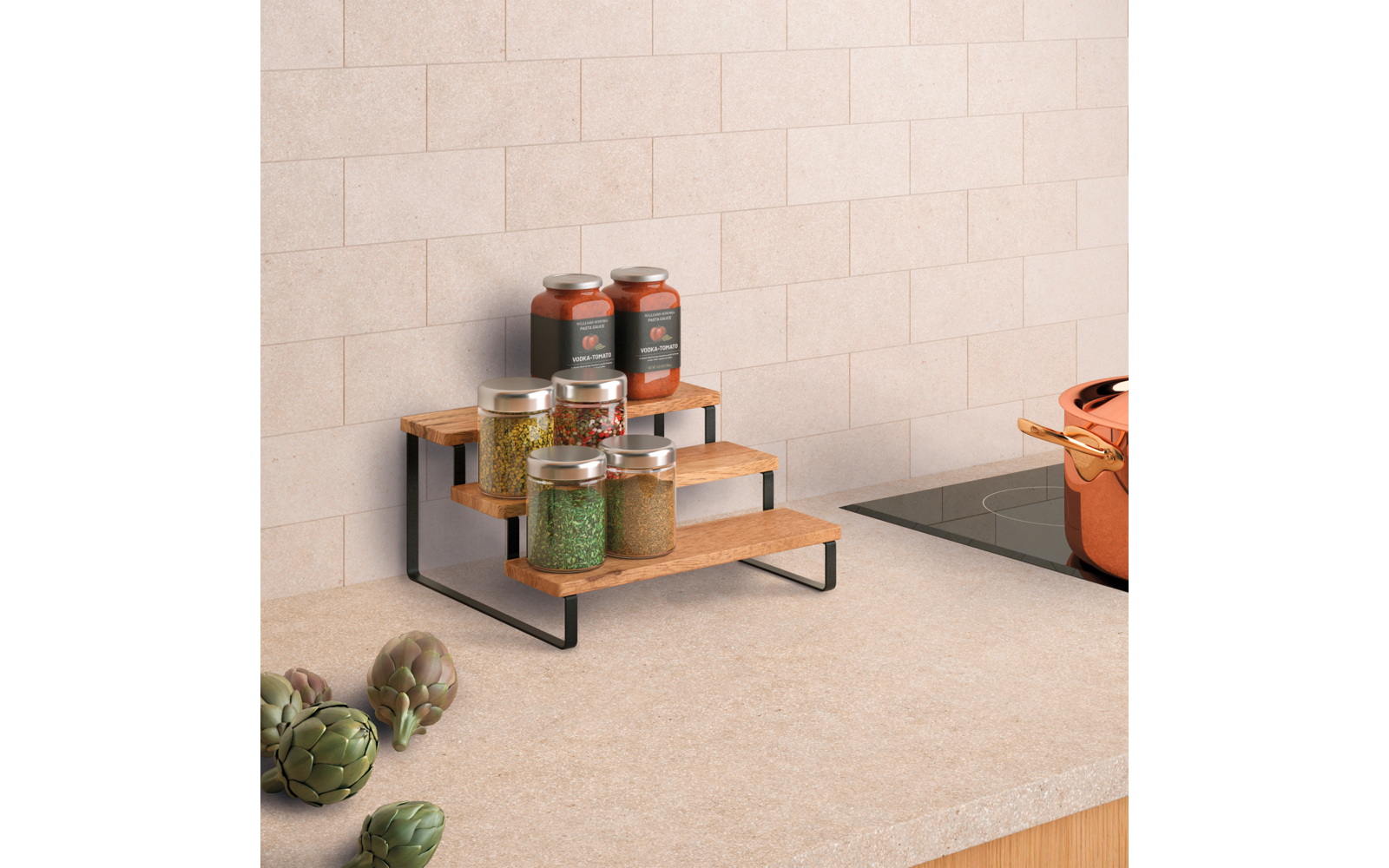 Dreistufiges Holzregal mit schwarzem Metallgestell auf einer Küchenarbeitsplatte, darauf Glasgefäße mit roten, grünen und gelben Inhalten; rechts ein schwarzes Kochfeld mit orangefarbenem Topf; links drei Artischocken; helle Kachelrückwand