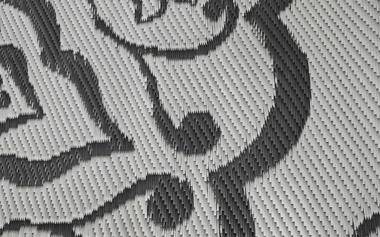 Nahaufnahme eines gerippten Stoffes mit schwarzer Kontur, die ein Gesicht und Punkte bildet