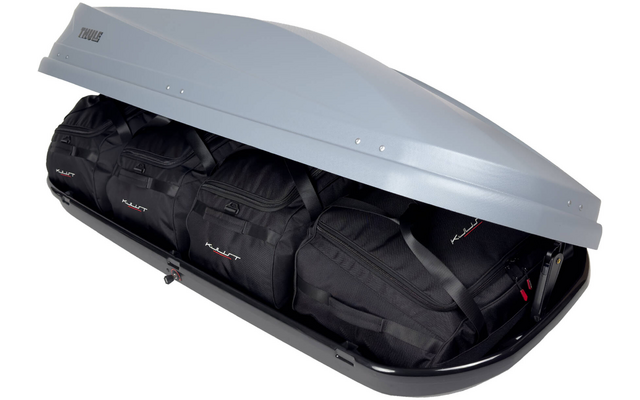 Silberne, geöffnete Dachbox auf schwarzer Basis, innen drei schwarze Reisetaschen