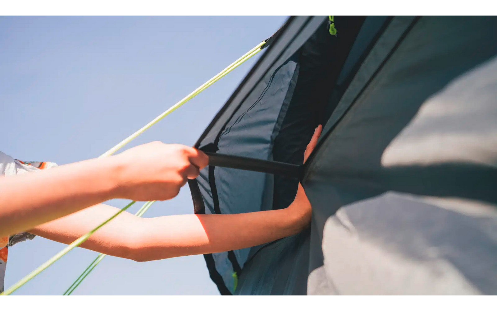 Hände befestigen ein Seil an einem Zelt