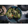 Grüner Salat in einer blauen Schüssel mit einem schwarzen Besteckstück