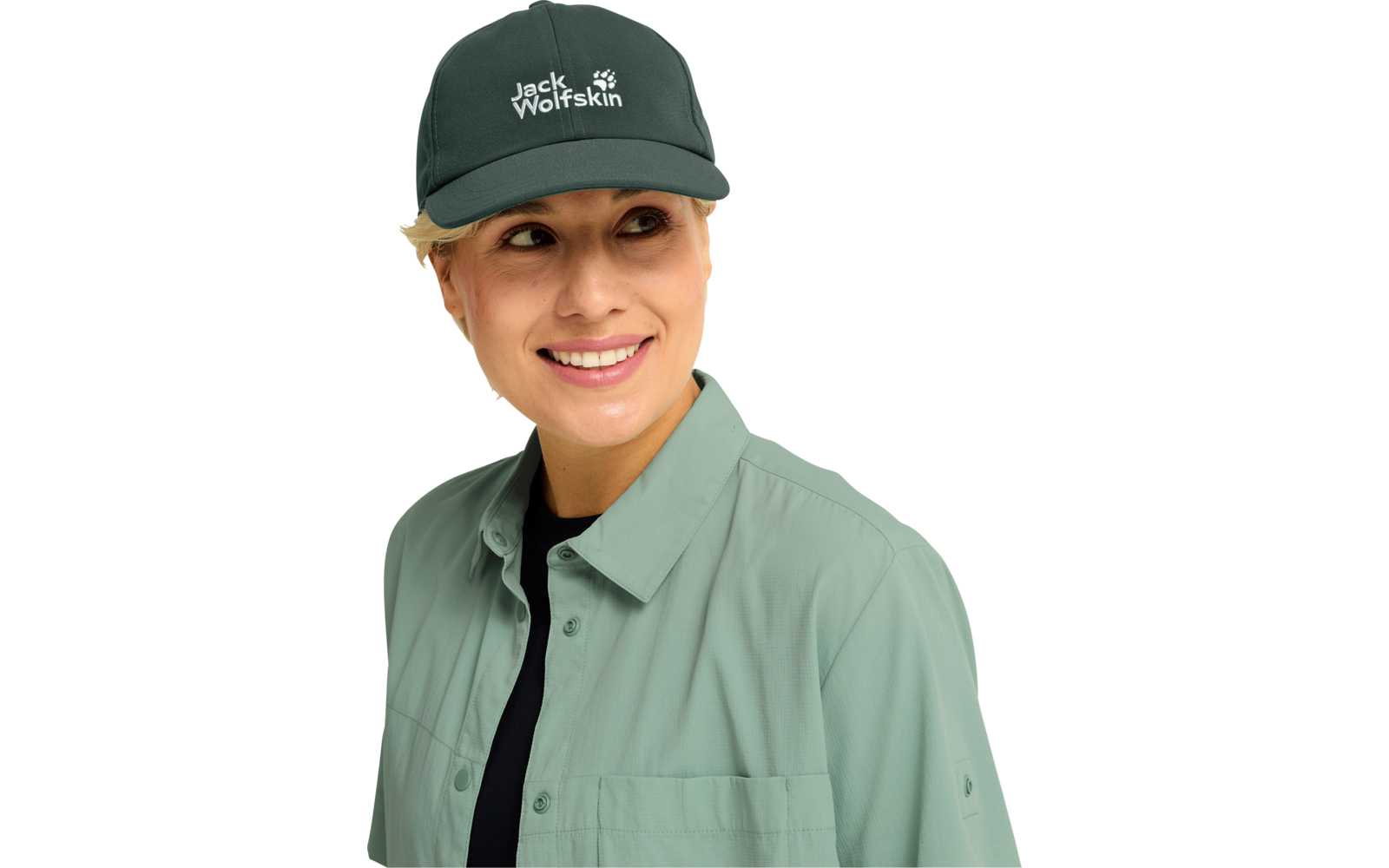 Person mit grünem Baseballcap mit 'Jack Wolfskin'-Logo, hellgrüner Hemdjacke und schwarzem Shirt, lächelnd, nach links blickend